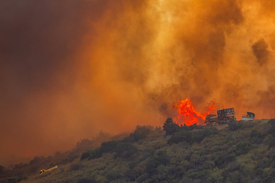Firefighters use a bulldozer to combat the Sandy Fire as it burns on a hill at a residential area in Simi Valley, California, on May 18, 2026.