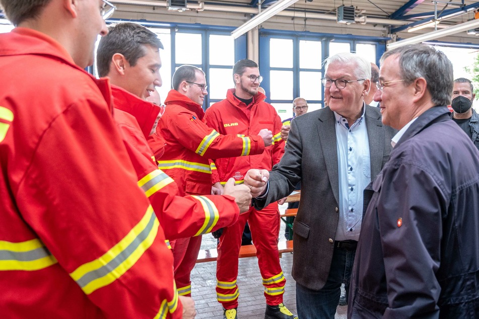 Nordrhein-Westfalen, Erftstadt: Bundespräsident Frank-Walter Steinmeier (2. v.r.) und Armin Laschet (r, CDU), Ministerpräsident von Nordrhein-Westfalen, unterhalten sich bei einem Besuch der Feuerwehrleitzentrale mit Helfern der Deutschen Lebens-Rettungs-Gesellschaft (DLRG).