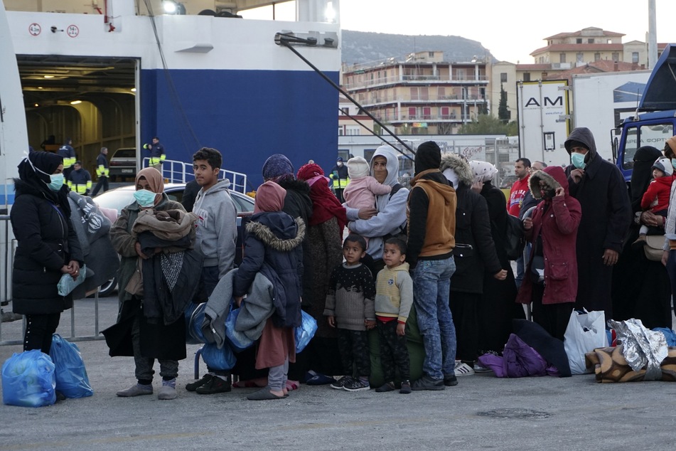Migranten stehen in einer Schlange, um im Hafen von Mytilene, auf der nordöstlichen Ägäisinsel Lesbos an Bord einer Fähre zu gehen.