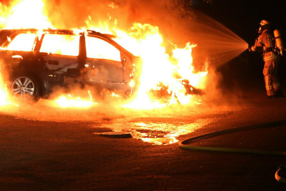Ein Feuerwehrmann versucht den Mercedes zu löschen.