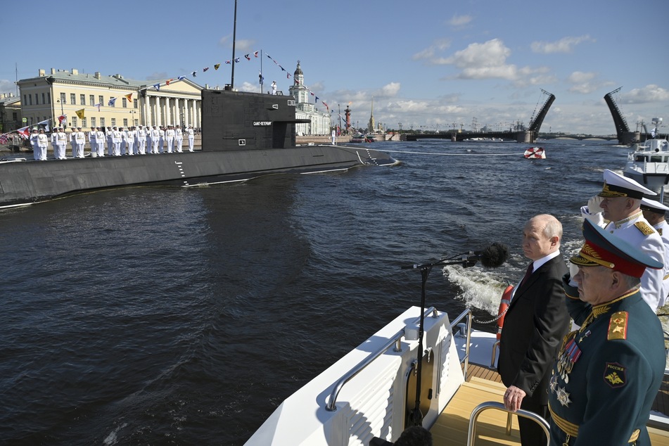 Wladimir Putin (70, l.), Verteidigungsminister Sergej Schoigu (68, r.) und Admiral Nikolai Jewmenow (61, m.), Oberbefehlshaber der russischen Marine, besichtigen Kriegsschiffe vor der großen Marineparade in Russland.