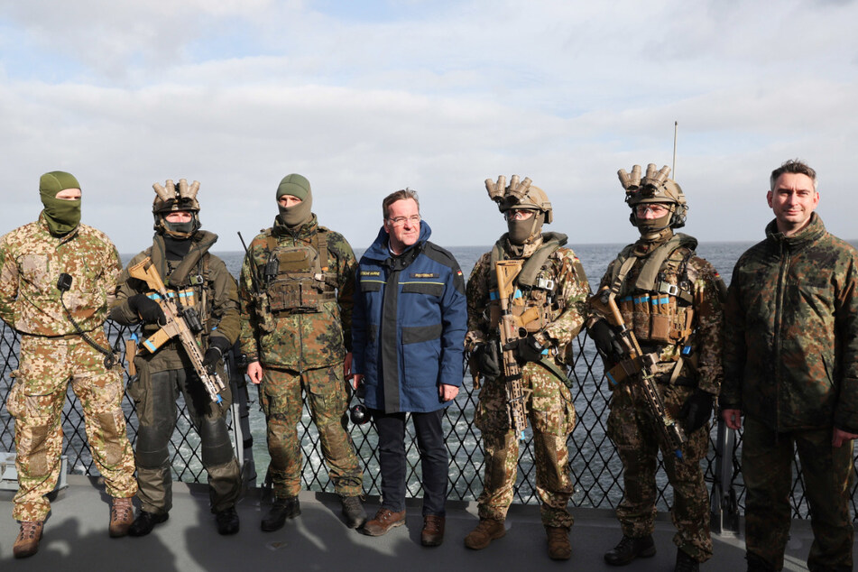 Der Verteidigungsminister zwischen Soldaten des KSM (Kommando Spezialkräfte Marine).