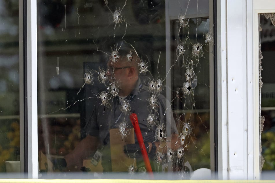 Several bullet holes can be seen in the grocer's shop window.