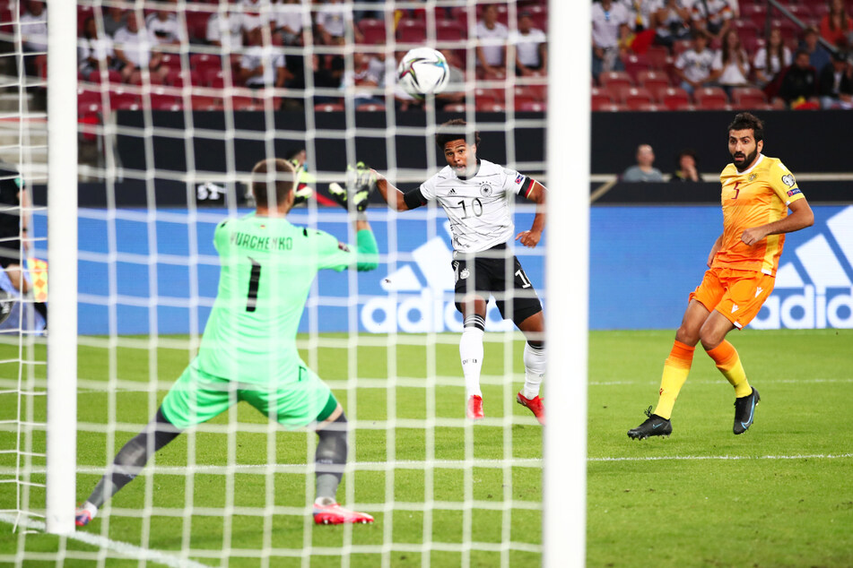 Die frühe Führung: Serge Gnabry (M.) jagt die Kugel an Armeniens Keeper David Yurchenko (l.) vorbei zum 1:0 ins Netz.