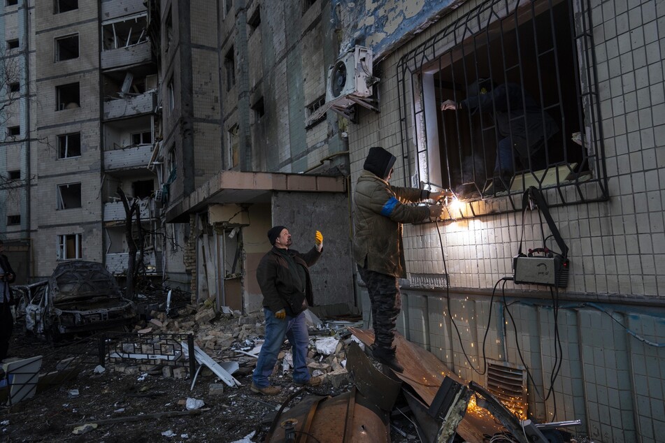 Der Besitzer einer Wohnung, die durch eine Bombe beschädigt wurde, schweißt die Gitterstäbe seiner Wohnung zusammen. Auch am späten Sonnabend stand Kiew unter Beschuss.