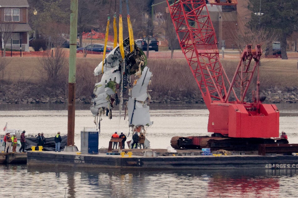 A large portion of the damaged plane fuselage is lifted from the Potomac River during recovery efforts after the American Airlines crash on February 3, 2025 in Arlington, Virginia.