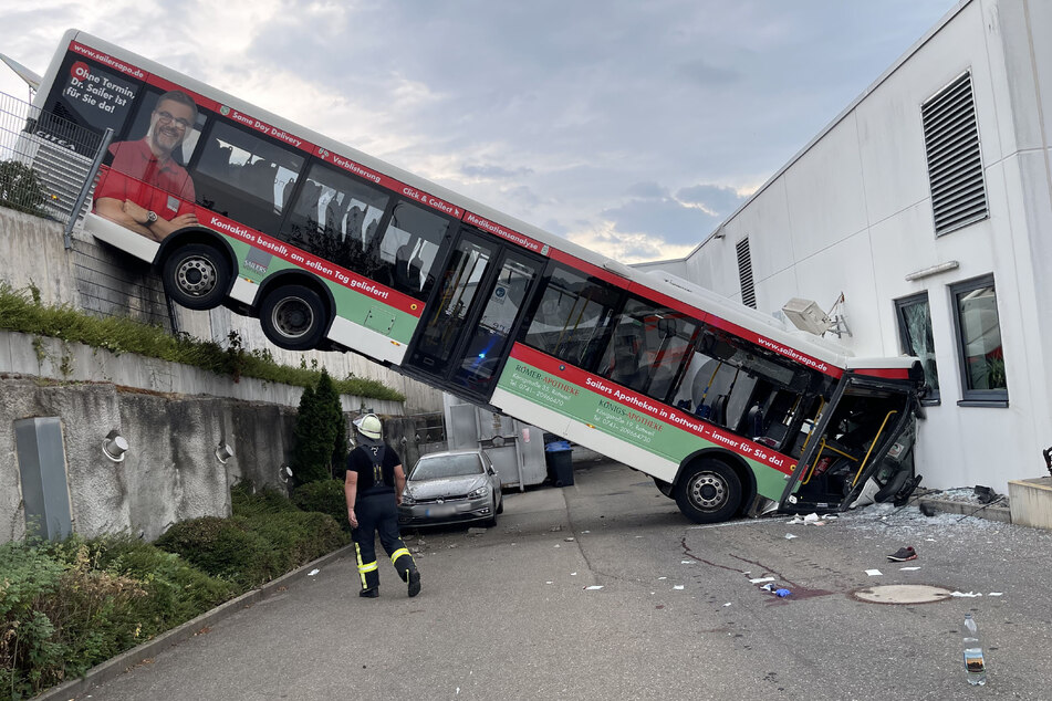 Bus stürzt nach Unfall mit Transporter Abhang hinunter und kracht in Discounter
