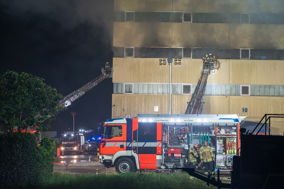 Feuerwehrleute kämpfen von außen gegen das Feuer im zweiten Stock des Gebäudes.