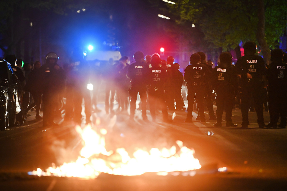 Polizei am Rande der Demonstration linker und linksradikaler Gruppen unter dem Motto "Demonstration zum Revolutionären 1. Mai", im Vordergrund ein Feuer auf der Straße.