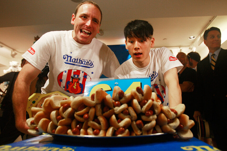 Takeru Kobayashi (r.) and Joey Chestnut (l.) look on at the Nathan's Famous Fourth of July International Hot Dog Eating Contest official weigh-in ceremony on July 2, 2009 in New York City.