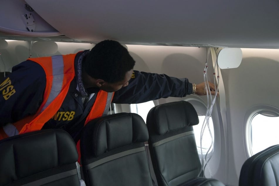 A member of the National Transportation Safety Board examines the fuselage of Alaska Airlines Flight 1282 Boeing 737-9 MAX on January 7, 2024 in Portland, Oregon.