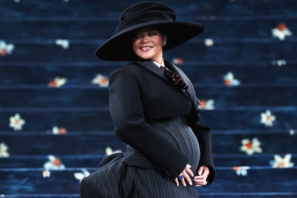Rihanna cradles her baby bump as she poses during the Met Gala in New York City on May 5, 2025.