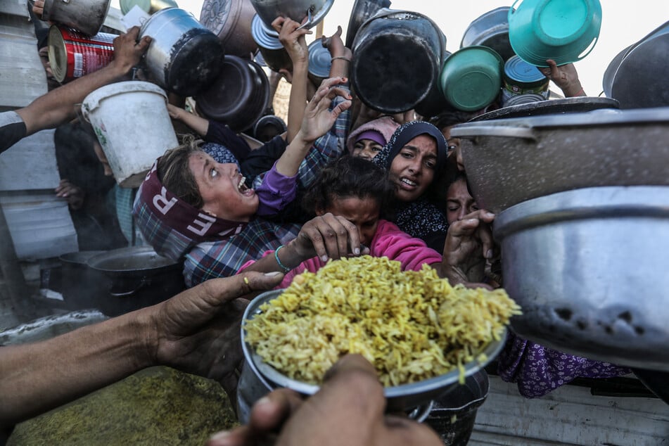 Vertriebene Palästinenser stehen dicht gedrängt, um Mahlzeiten von der Rafah Charitable Kitchen (Tekia) in Chan Junis zu erhalten.