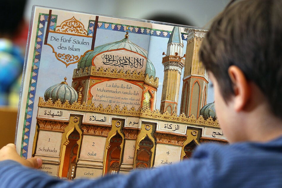 Ein Junge liest während des islamischen Religionsunterrichts in einem Schulbuch.