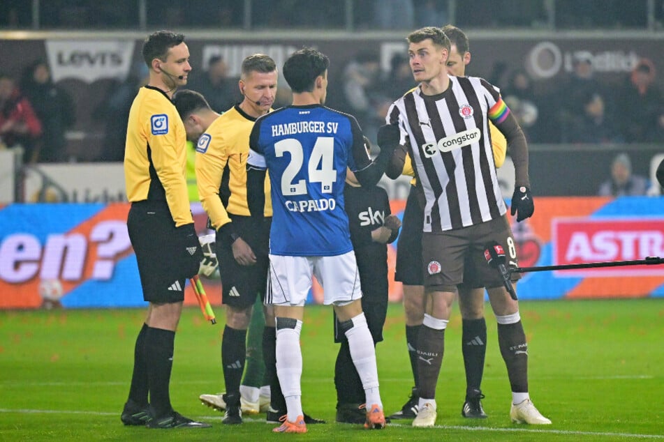 Die Unparteiischen bei der Seitenwahl vor dem Anpfiff mit den Kapitänen.