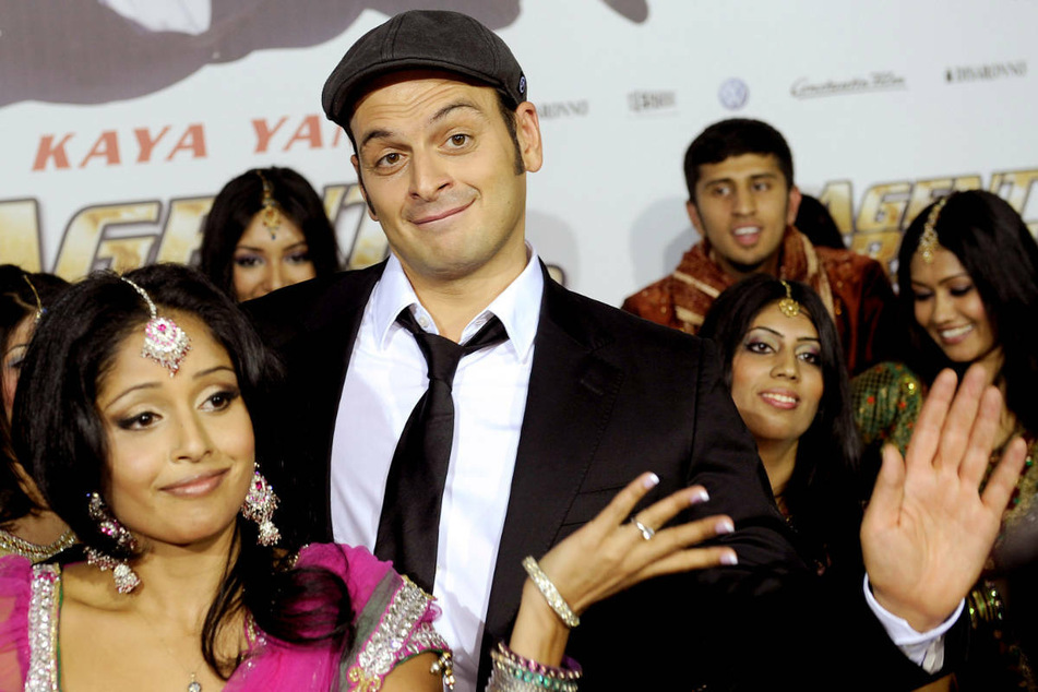 Kaya Yanar (M.) posiert am 17. Oktober 2012 bei der Premiere des Kinofilms "Agent Ranjid rettet die Welt" in Köln zusammen mit Tänzerinnen.