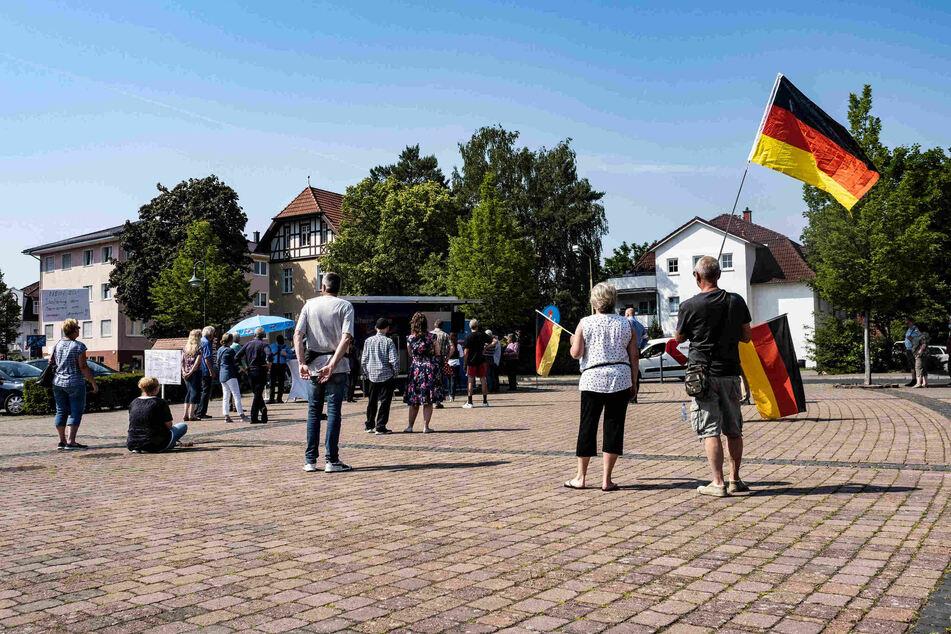 Einige Anhänger und Parteimitglieder der AfD Oder-Spree stehen auf dem Marktplatz der brandenburgischen Gemeinde Grünheide und protestieren gegen den geplanten Bau der Tesla-Fabrik.
