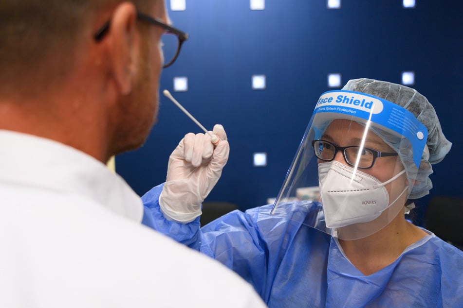 Ein Reisender lässt sich in der Corona-Teststation am Flughafen Dresden International auf das Coronavirus testen.