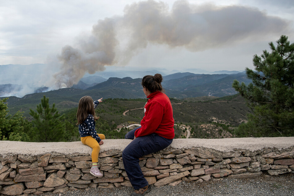 Eine Frau und ein Mädchen betrachten die Rauchschwaden in San Agustin.