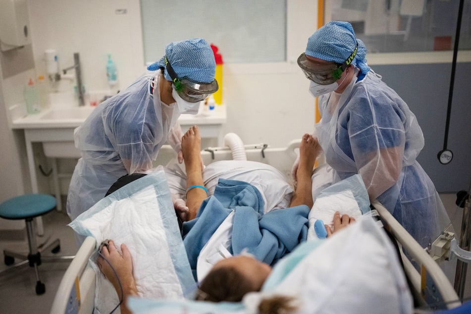 Krankenschwestern versorgen einen Corona-Patienten auf der Intensivstation einer Klinik.