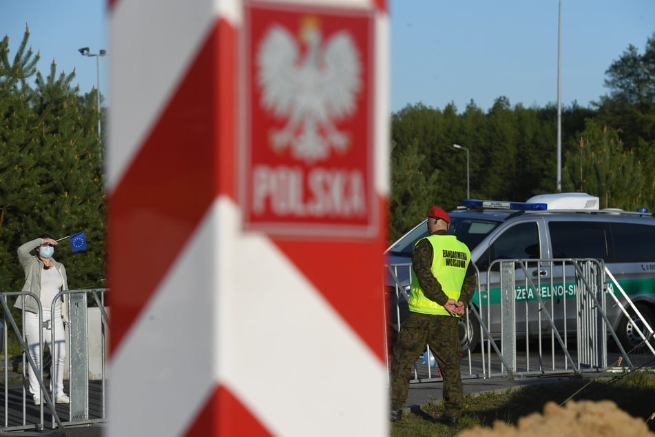 ine Frau aus Polen schaut über die geschlossen Grenze noch Deutschland.