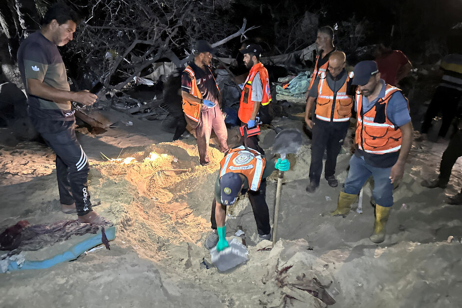 Emergency responders and refugees dig for remains in the sands of Al-Mawasi after the Israeli bombing.