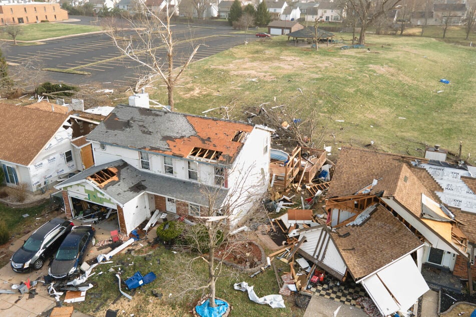 Debris lies around damaged houses the morning after a tornado touched down in Florissant, Missouri.