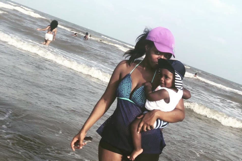 Porsha Ngumezi is pictured holding one of her sons at the beach.