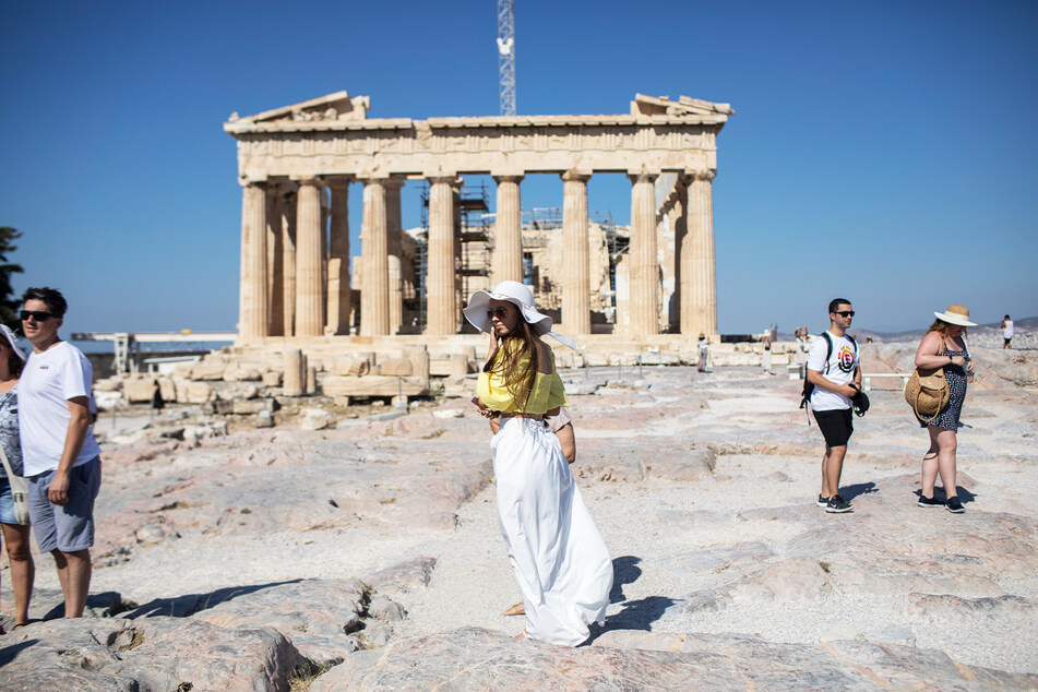 Touristen spazieren über die Athener Akropolis.