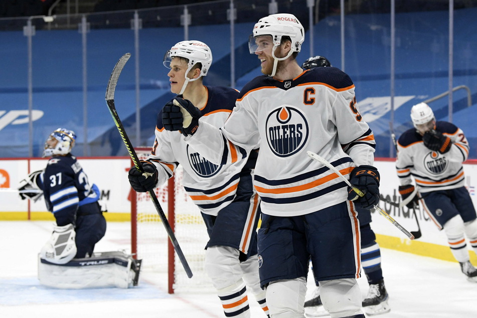 Connor McDavid (c.) assisted on all three of his team's goals as they beat the Jets 3-1.