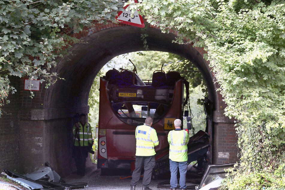 Rettungskräfte stehen neben einem Bus ohne Dach in der Well House Lane.