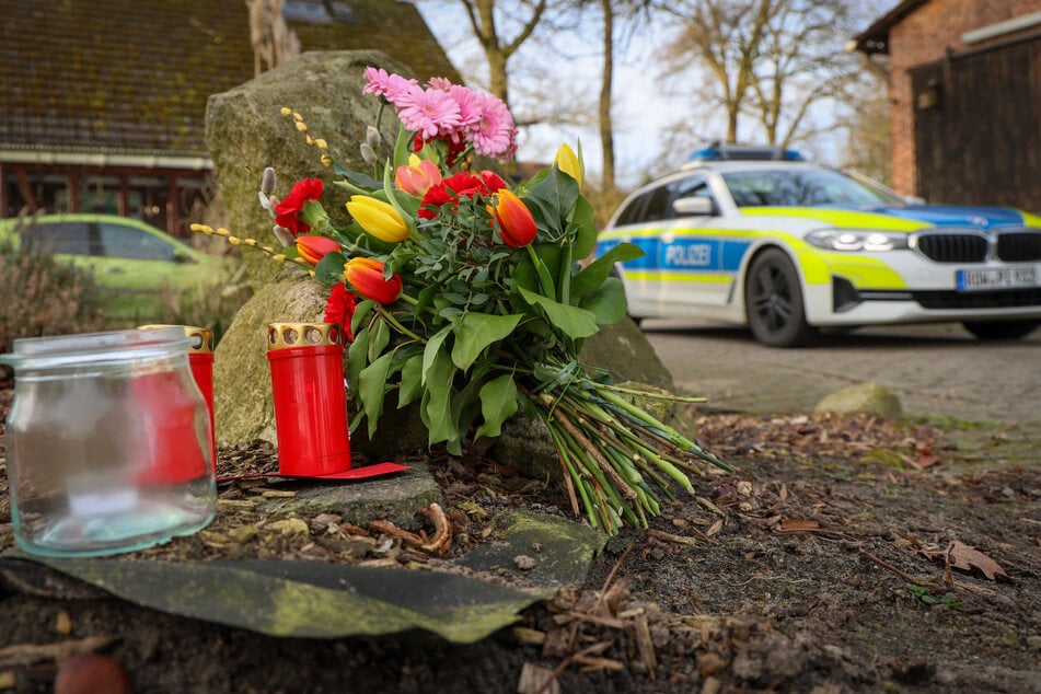 Blumen und Kerzen stehen vor einem Haus in Westervesede in der Gemeinde Scheeßel, wo es zu den tödlichen Schüssen kam.