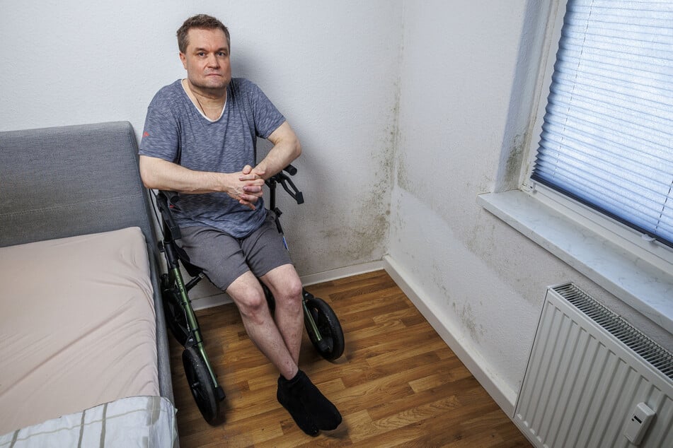 Mike Kettner (48) vor der Schimmelwand in seinem Schlafzimmer.