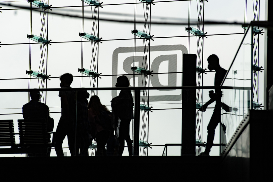 Bahnreisende sind nur als Silhouetten in der Glasfassade zu sehen. Die Deutsche Bahn streikt mehrere Tage. Viele Züge stehen still.