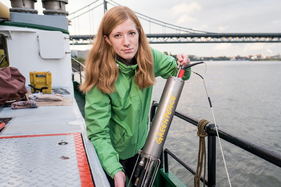 Eine Greenpeace-Helferin beim Einsammeln der Proben aus dem Rhein.