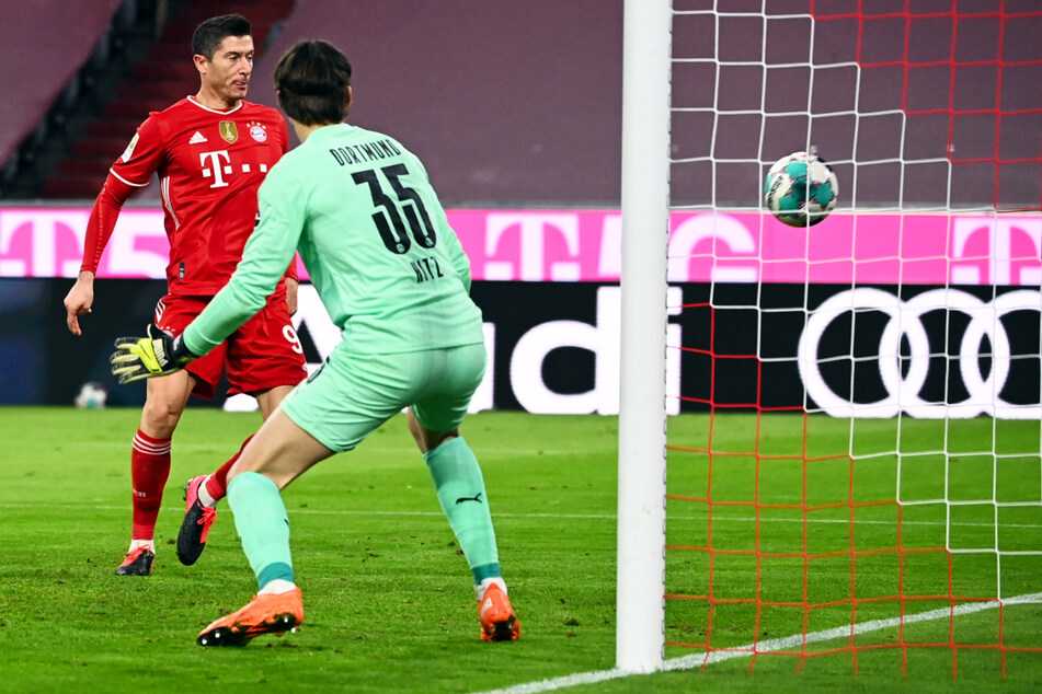 Der Anschlusstreffer: Robert Lewandowski (l.) bringt den FC Bayern München mit seinem Tor zum 1:2 aus Münchner Sicht zurück ins Spiel. BVB-Keeper Marwin Hitz kann nur chancenlos hinterherschauen.