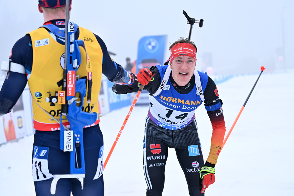 Benedikt Doll (33, r.) gewinnt den Sprint und wird im Ziel von Norwegens Johannes Thingnes Bö (30, l.) beglückwünscht.