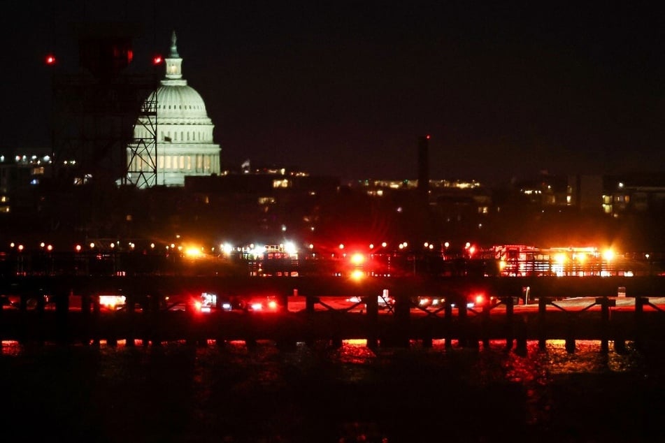 The US Capitol is visible as emergency response units assemble on the tarmac at Ronald Reagan Washington Airport as search and rescue operations are underway in the Potomac River.