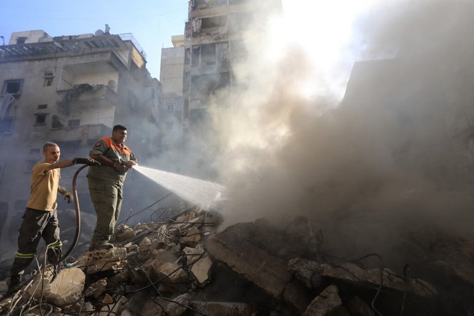 Members of the Lebanese civil defense battle a fire at the site of an Israeli strike on Beirut's Basta neighborhood on October 11, 2024.