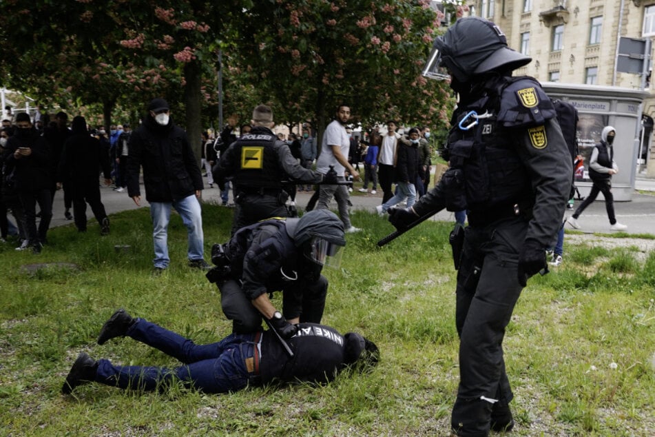Die Polizei nimmt einen Protestler fest.