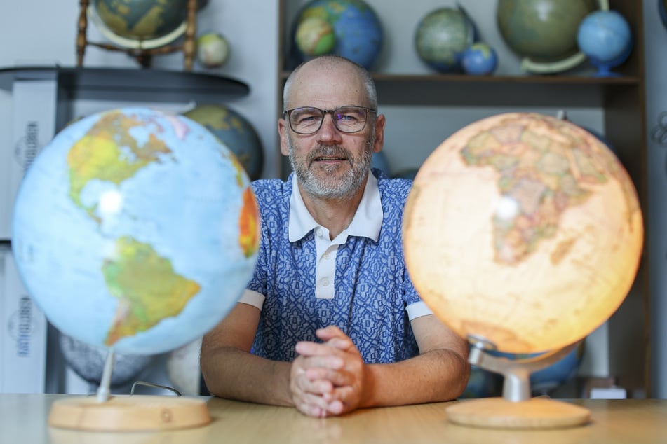 Thomas Härtel, Verlagsleiter der Räthgloben 1917 Verlags GmbH, zwischen verschiedenen Globen. Bei Räthgloben entstehen die Weltkugeln noch in Handarbeit.