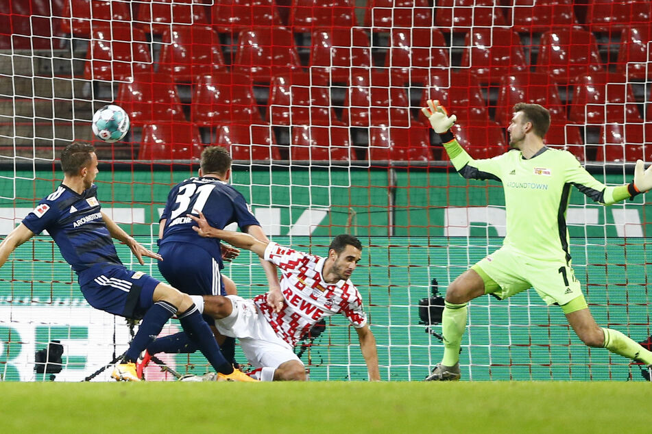 Kölns Ellyes Skhiri (M.) trifft gegen Unions Torwart Andreas Luthe (r.) zum 1:1.