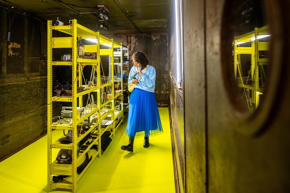 Eine Frau schaut sich die Ausstellung "Ersatzteillager" im Fahrzeugmuseum an.