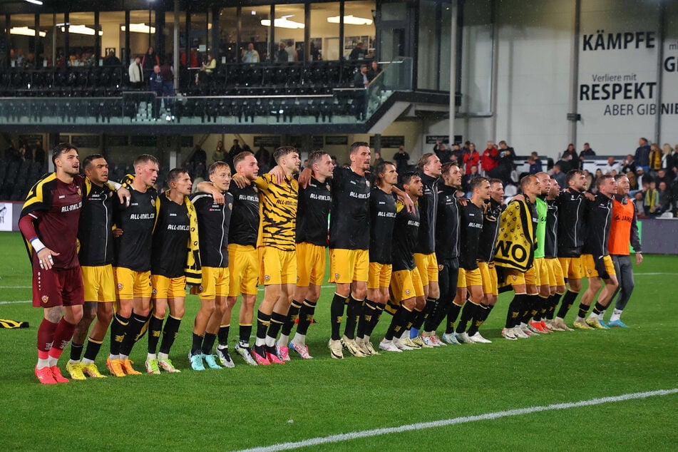 Hüpfen vor den 1020 mitgereisten Fans: Die Dynamo-Profis feierten durch den Regen pitschnass ihren glücklichen 3:0-Sieg in Verl ausgelassen.