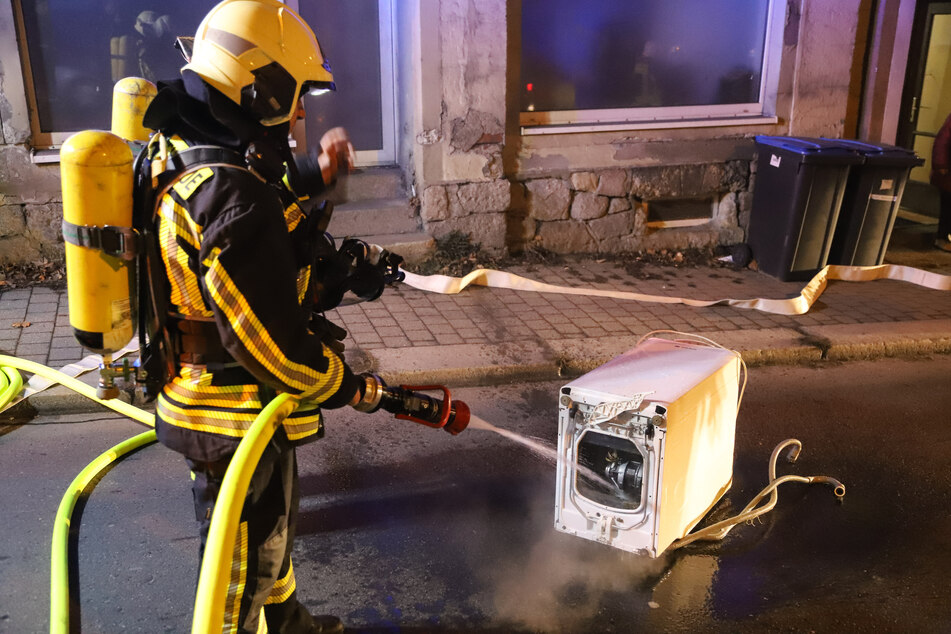 In Aue war eine Waschmaschine in Brand geraten. Die Feuerwehr brachte das Gerät nach draußen.
