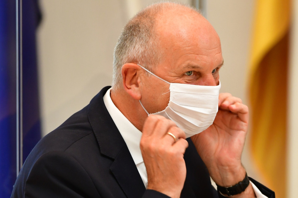 Dietmar Woidke (SPD), Ministerpräsident von Brandenburg, legt sich während der Sitzung des Brandenburger Landtages einen Mund-Nasenschutz an.