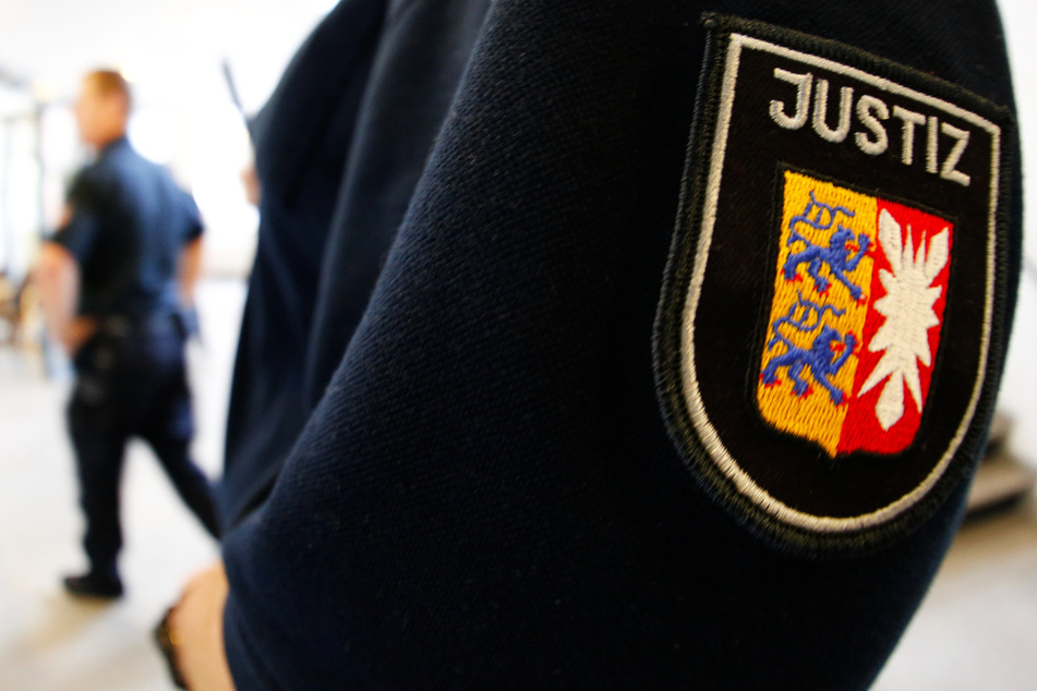 Ein Justizbeamter steht in einem Gerichtssaal. In Itzehoe ist ein 33-Jähriger wegen heimtückischen Mordes zu lebenslanger Haft verurteilt worden. (Symbolbild)