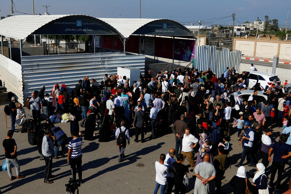Palestinians with dual nationality gather at the Rafah border to Egypt on Monday in the hopes of being let through.