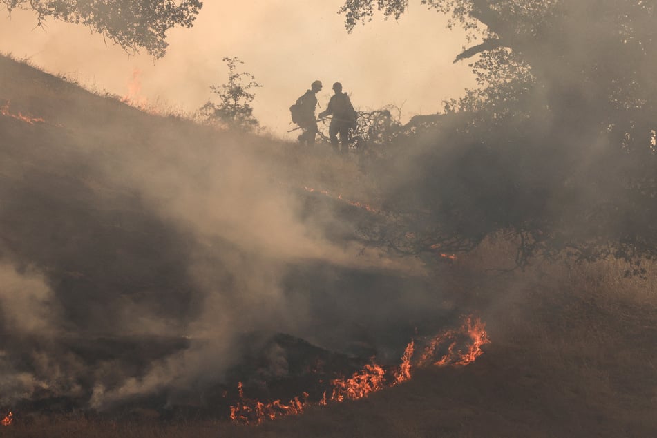 Firefighters tackle the Madre Fire near New Cuyama, California, on July 3, 2025.