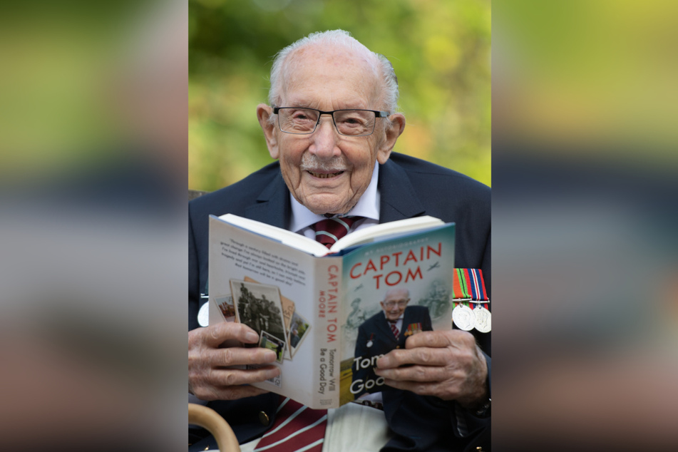 Sir Tom Moore hält in seinem Haus am Tag der Veröffentlichung seiner Autobiografie "Tomorrow Will Be A Good Day" ein Exemplar des Buchs in den Händen.